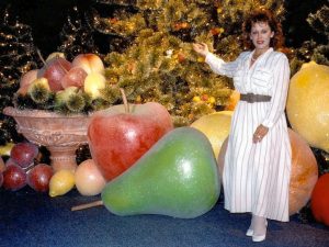 giant fiberglass fruits on display with woman for scale