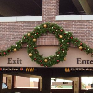 giant wreath hangs above parking garage entrance exit